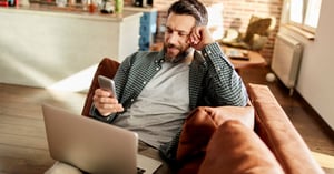 Teacher working from home using his laptop and mobile phone