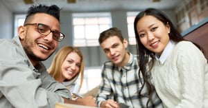 A group of four students smiling into the camera