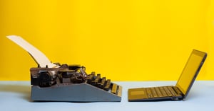 Une vieille machine à écrire et un ordinateur portable