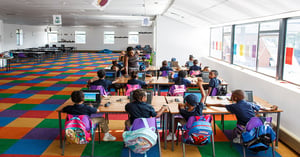 Students and a teacher in a colorful classroom.